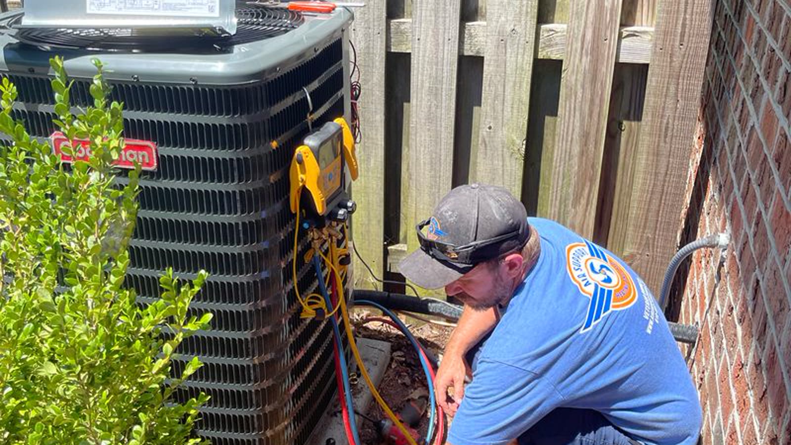 Air conditioning technician checking an outdoor condenser at a Mesa home